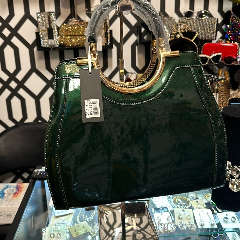 A emerald green patent vegan purse with gold trim